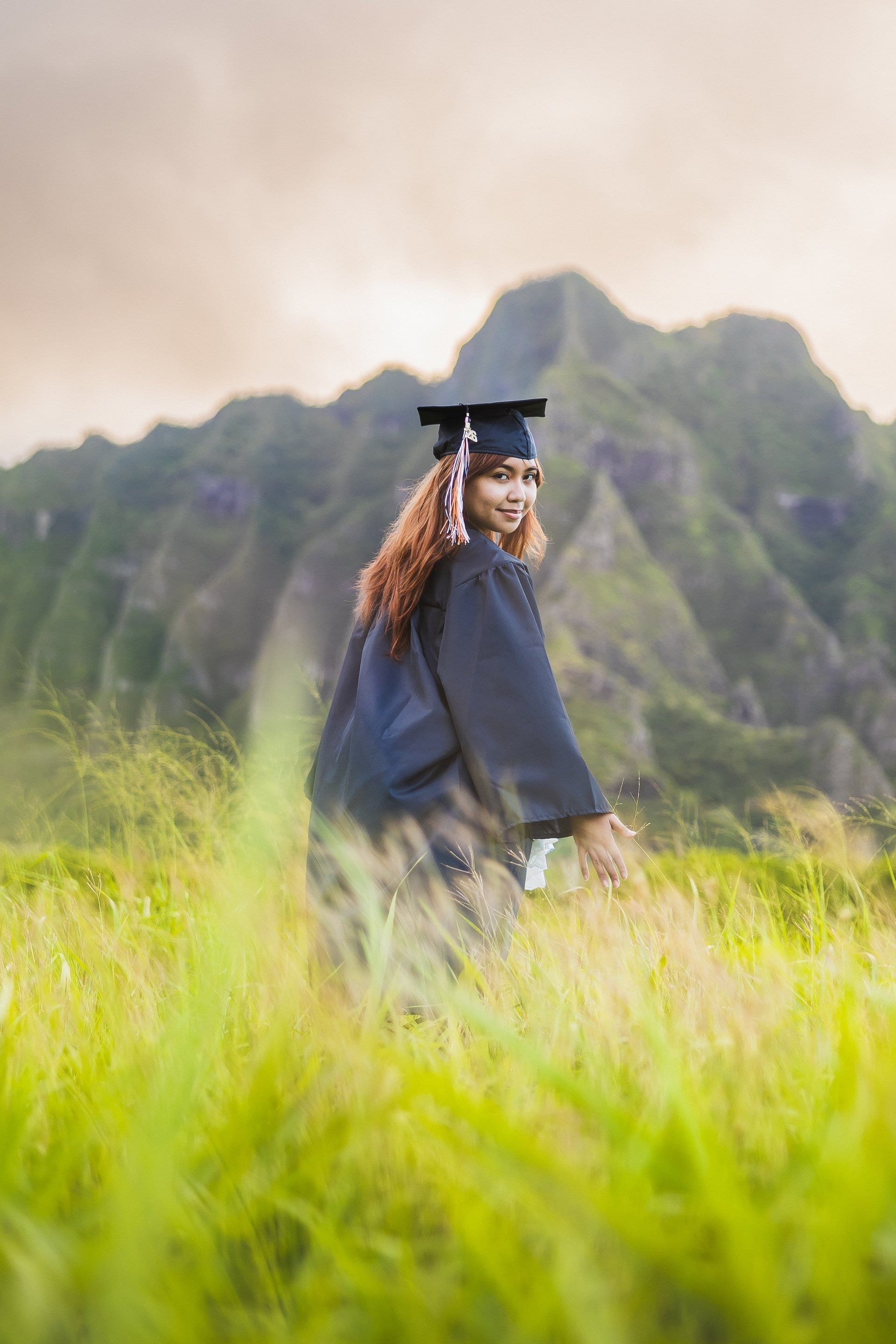 Graduate celebrating in cap and gown at Kualoa Ranch on Oahu Hawaii